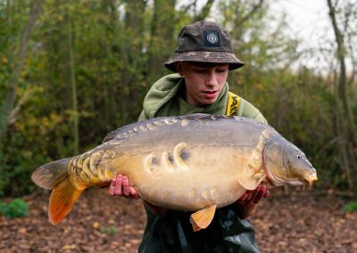 Young angler holding a mirror carp at Scarlett’s Lake